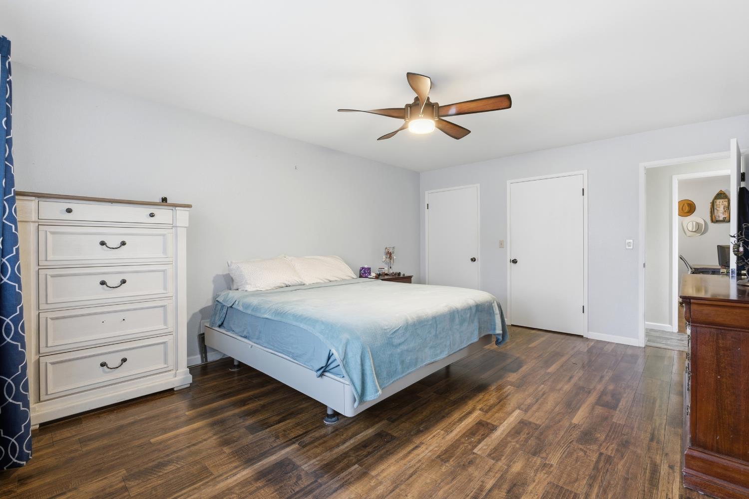 12126 Topper Road Madera, CA 93636 - Photo 21 of 40 a bedroom with a bed and a ceiling fan
