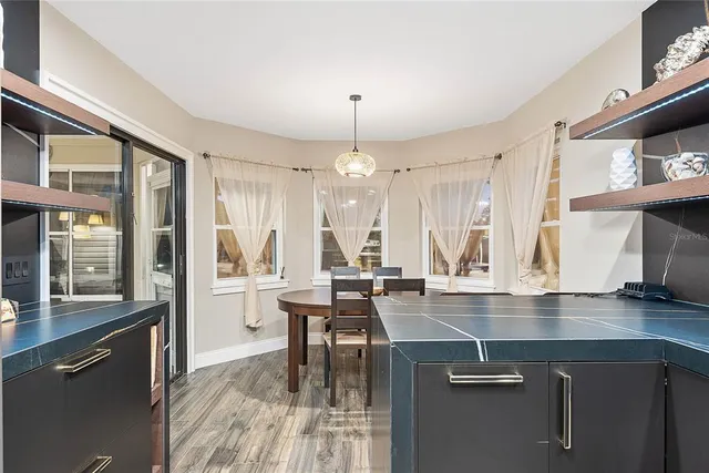 a view of a patio with couches and a table and chairs with wooden floor and fence