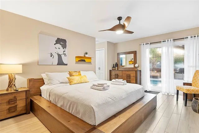 a view of a white house with a large tree in front of it