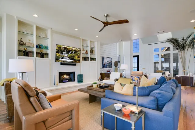 a living room with fireplace furniture and a view of kitchen