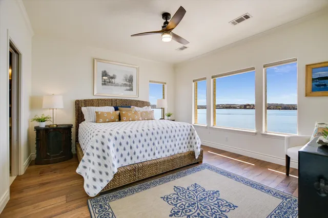 a bedroom with a beds chandelier and a window