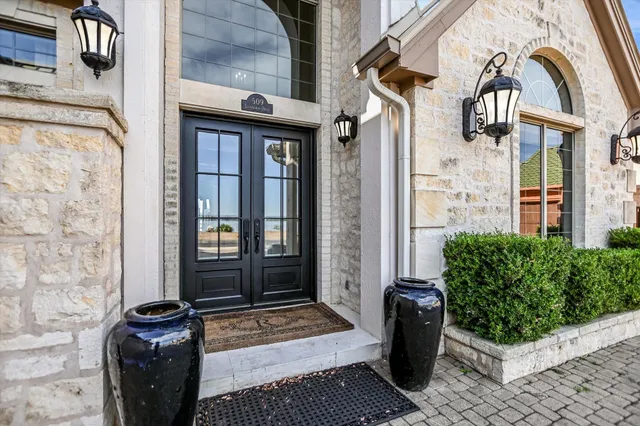 a view of a brick house with potted plants