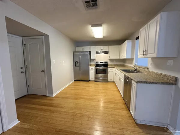 a kitchen with stainless steel appliances granite countertop a refrigerator and a stove top oven