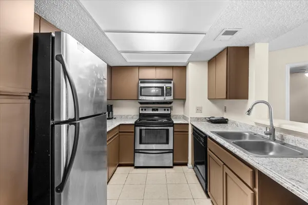 a kitchen with stainless steel appliances granite countertop a refrigerator and a sink