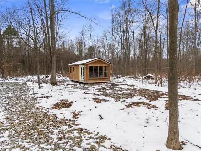 a front view of a house with a yard covered in snow
