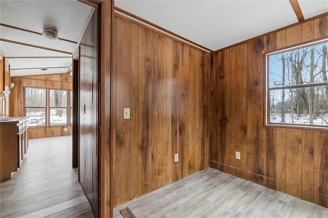 a view of a hallway with wooden floor and windows