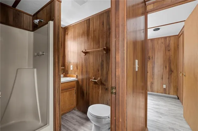 a bathroom with a granite countertop shower a toilet and a sink