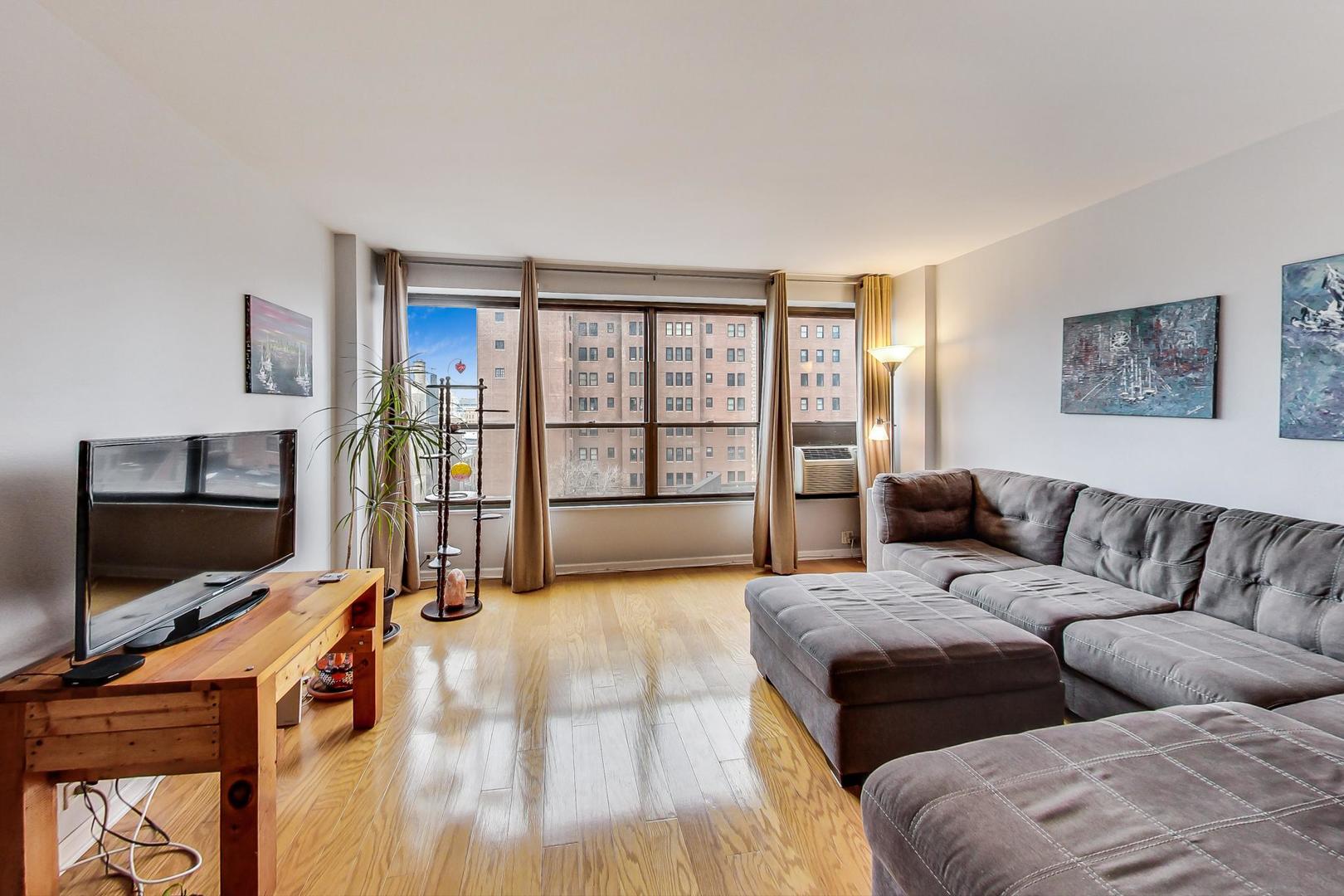 2930 North Sheridan Road, Unit 802 Chicago, IL 60657 - Photo 5 of 30 a living room with couches large flat screen tv and kitchen view