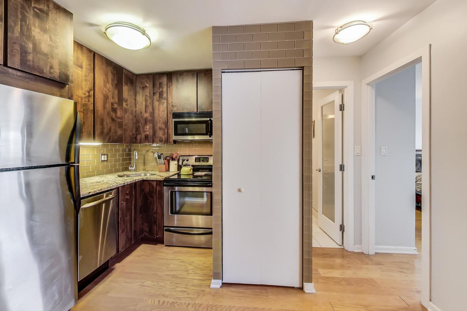 2930 North Sheridan Road, Unit 802 Chicago, IL 60657 - Photo 7 of 30 a kitchen with stainless steel appliances granite countertop a refrigerator and a stove