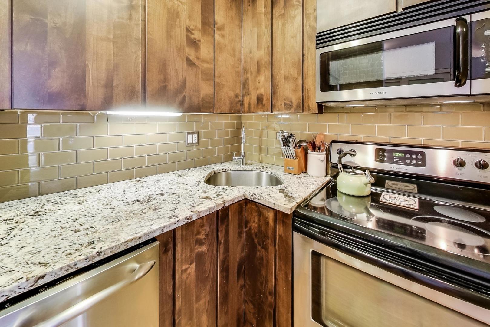 2930 North Sheridan Road, Unit 802 Chicago, IL 60657 - Photo 8 of 30 a kitchen with a sink stove and microwave