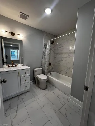 a bathroom with a bathtub a sink a toilet a mirror and vanity