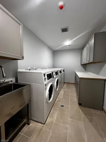a utility room with dryer washer and a view of living room