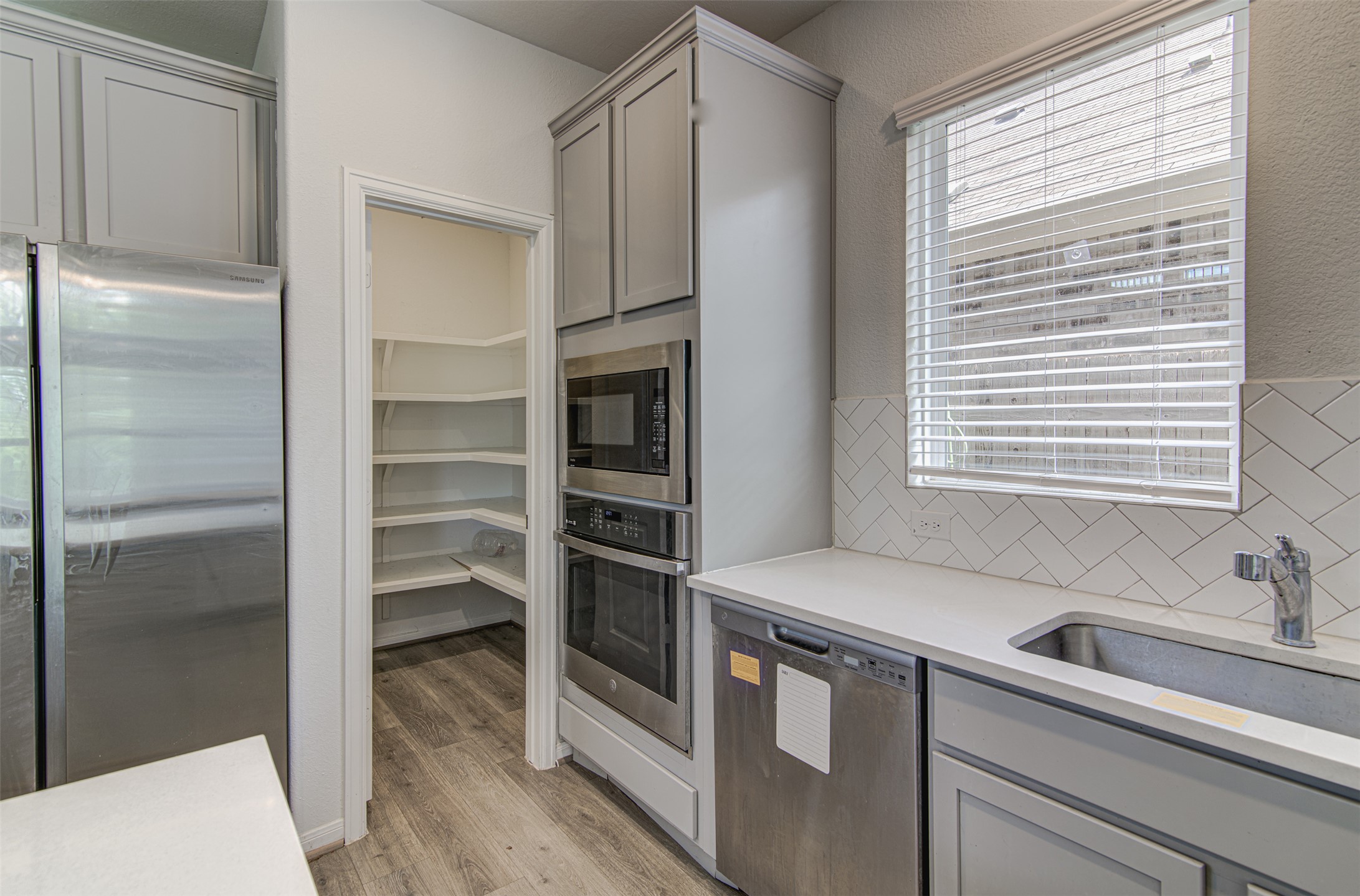 774 Cherrystone Loop Buda, TX 78610 - Photo 8 of 38 A streamlined kitchen showcasing stainless steel appliances and an organized pantry.