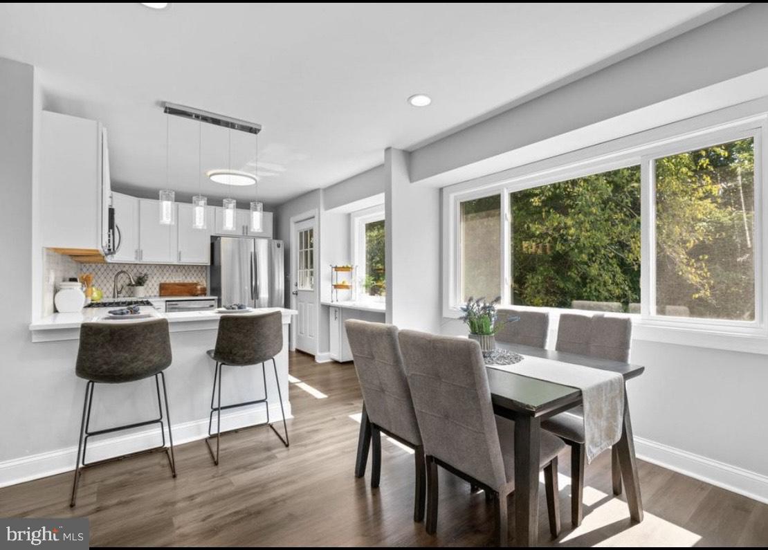 9802 Cherry Tree Lane Silver Spring, MD 20901 - Photo 8 of 33 a view of a dining room with furniture large windows and wooden floor