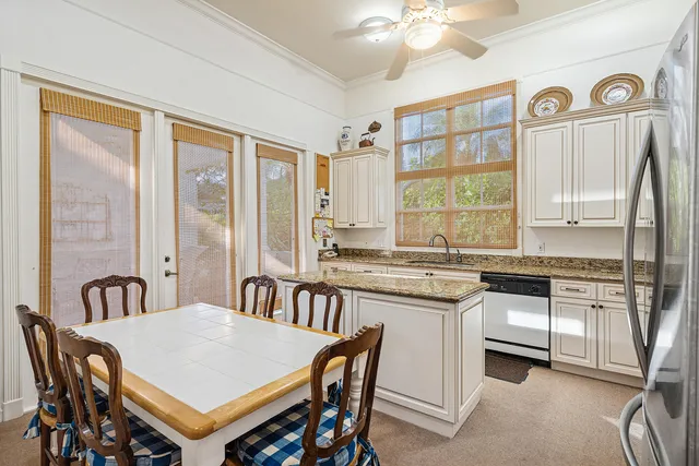 a large kitchen with kitchen island a large window a sink and stainless steel appliances