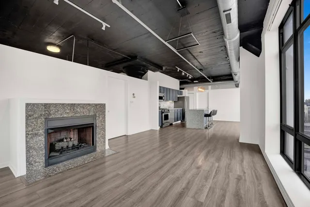 a view of empty room with wooden floor and fireplace