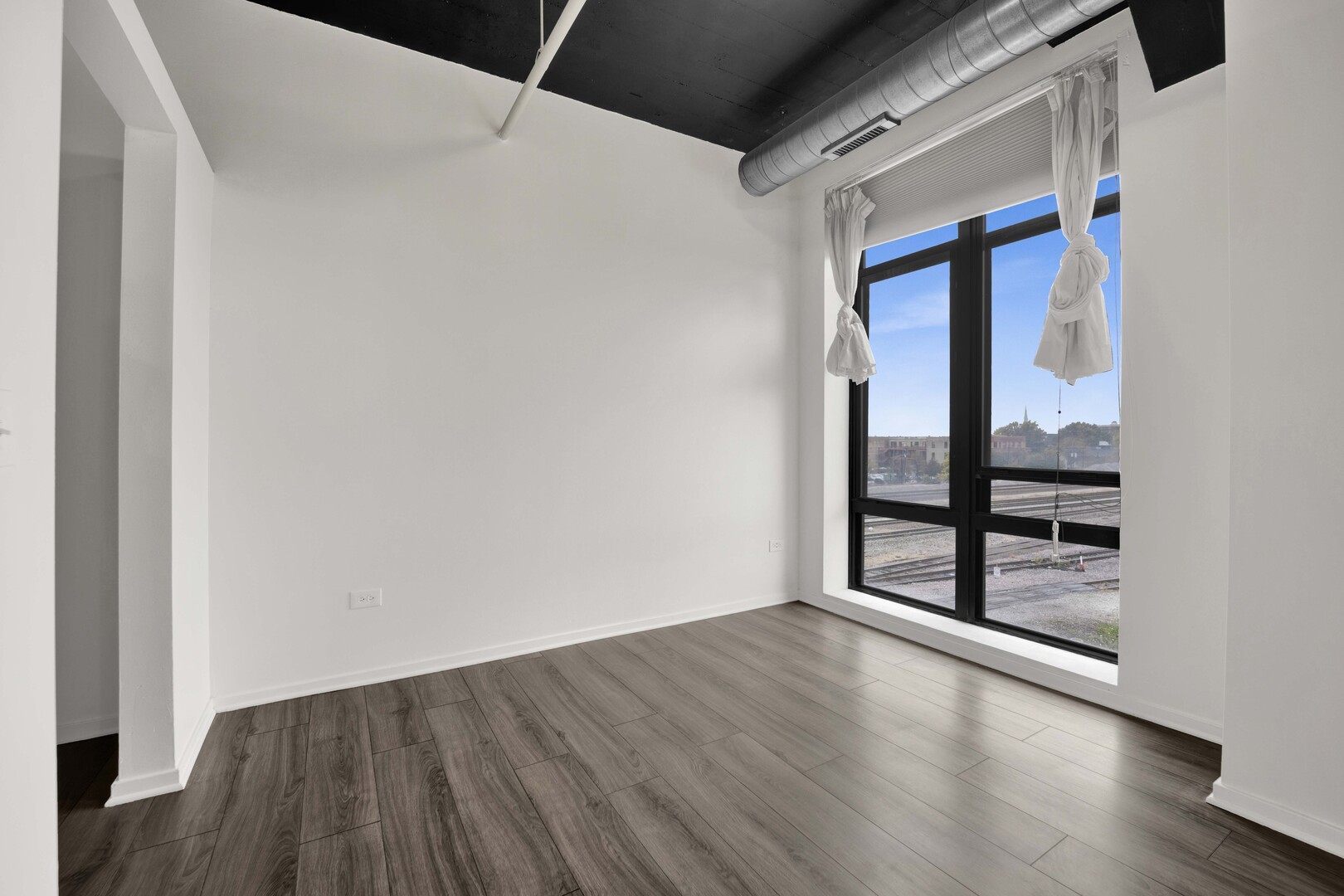 1524 South Sangamon Street, Unit 401 Chicago, IL 60608 - Photo 12 of 55 a view of an empty room with wooden floor and windows