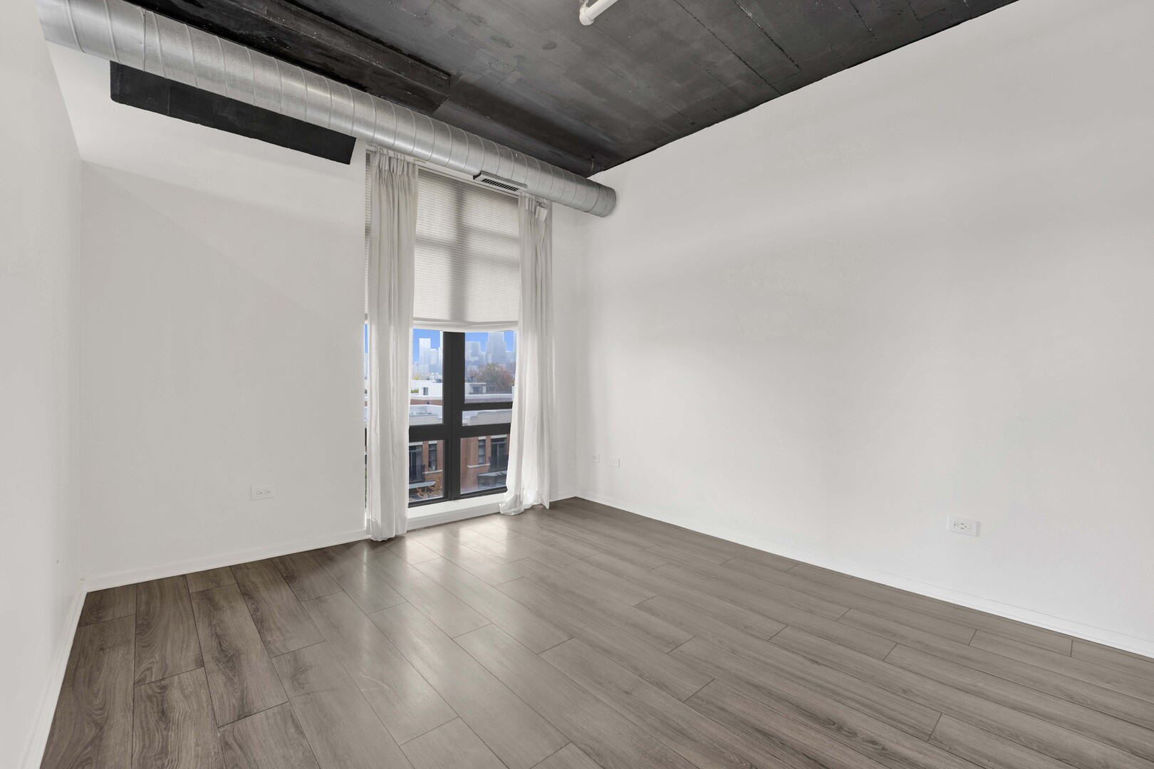 1524 South Sangamon Street, Unit 401 Chicago, IL 60608 - Photo 16 of 55 a view of an empty room with wooden floor and a window