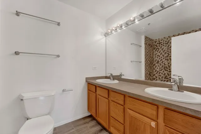 a bathroom with a granite countertop sink a toilet and a mirror