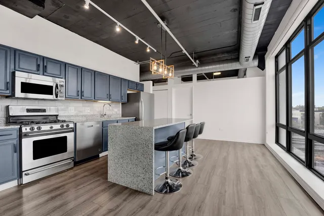 a kitchen with granite countertop a stove and a wooden floor