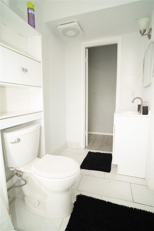 2136 Ridgeway Street Arlington, TX 76010 - Photo 13 of 32 a white toilet sitting next to a bathroom sink
