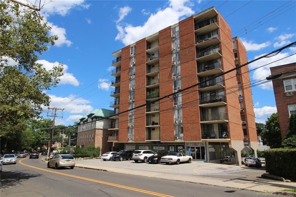 a city street lined with buildings and a cars parked on the road