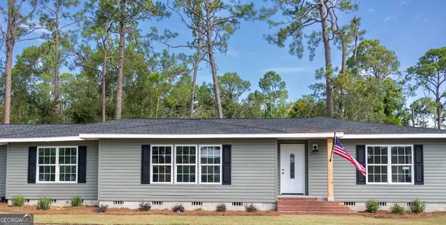 a front view of a house with a tree