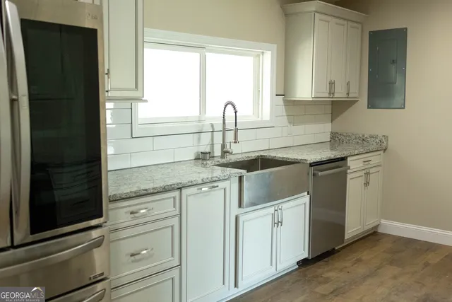 a kitchen with white cabinets and sink