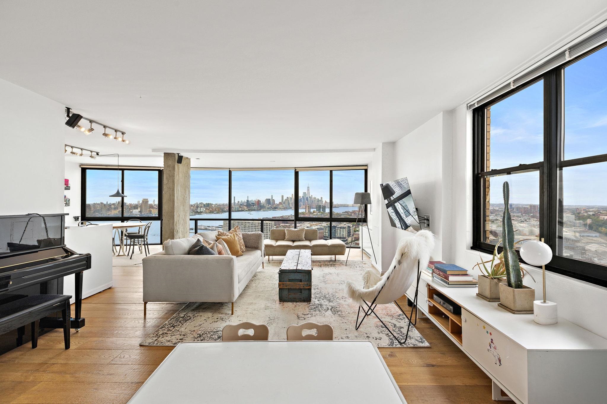 a living room with furniture large windows and a table