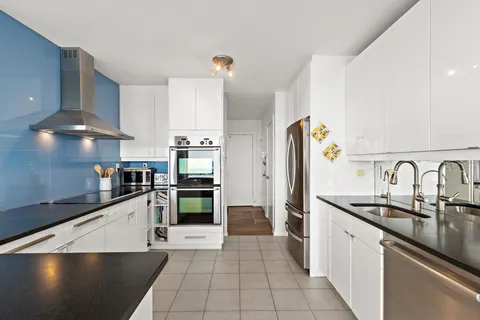 a kitchen with stainless steel appliances a sink a stove and refrigerator