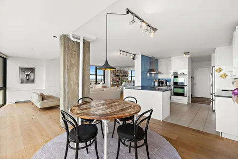 a dining room with stainless steel appliances kitchen island a table and chairs