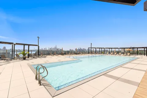 a view of swimming pool with outdoor seating and city view