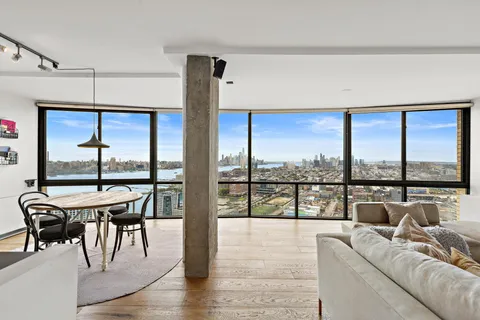 a living room with furniture tv and large windows