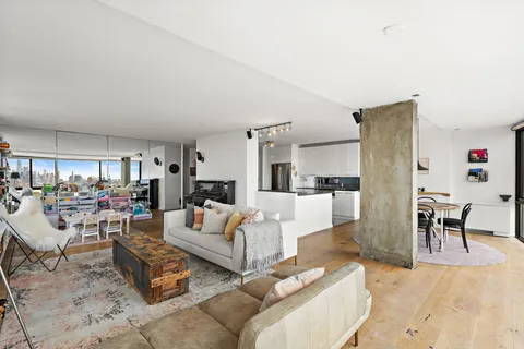 a living room with furniture and a dining table with kitchen view