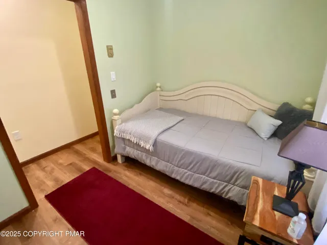 a bedroom with a bed and wooden floor