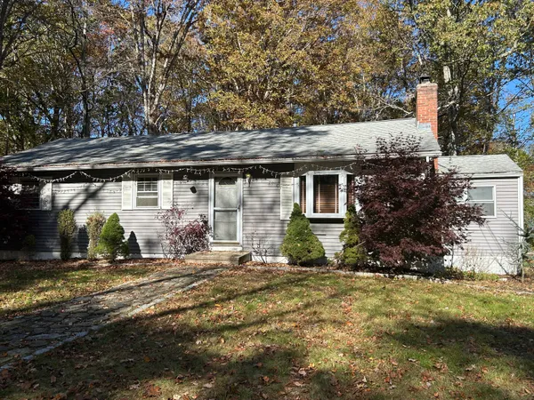 a backyard of a house with large trees and outdoor seating