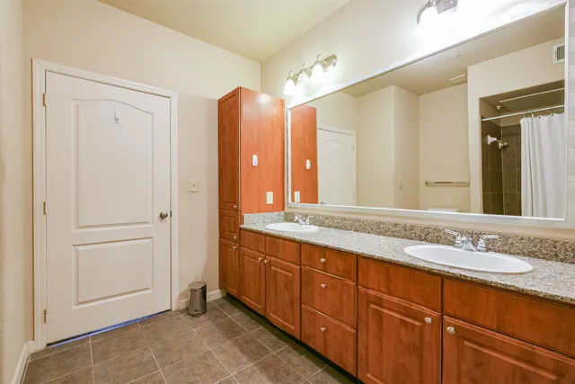 a spacious bathroom with a double vanity sink and a mirror