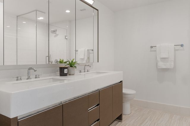 a bathroom with a sink a toilet and a mirror