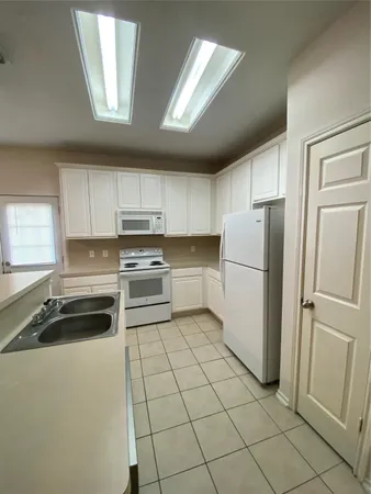 a kitchen with a refrigerator sink and cabinets