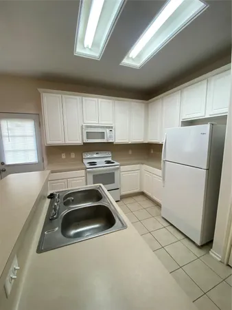 a kitchen with a refrigerator sink and cabinets
