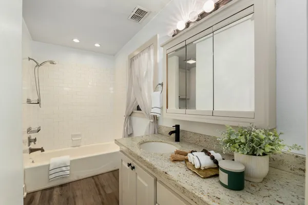 a bathroom with a granite countertop sink a toilet and shower