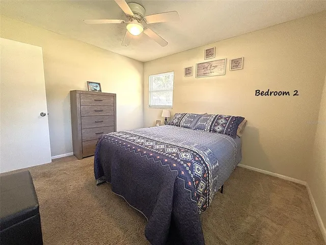 a bed sitting in a bedroom next to a window with a chandelier