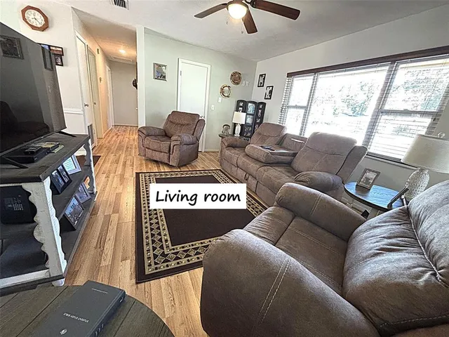 a living room with furniture a flat screen tv and a large window