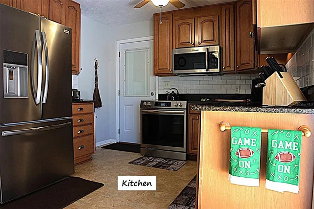 a kitchen with stainless steel appliances granite countertop a stove a microwave and a refrigerator