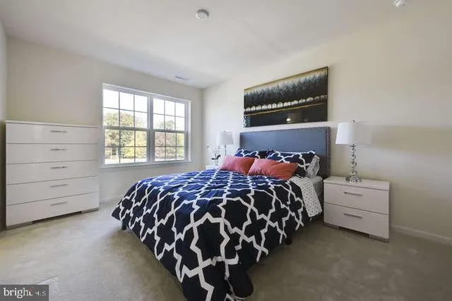 a bed sitting in a bedroom next to a window with a dresser