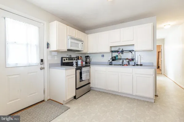 a kitchen with white cabinets and white appliances