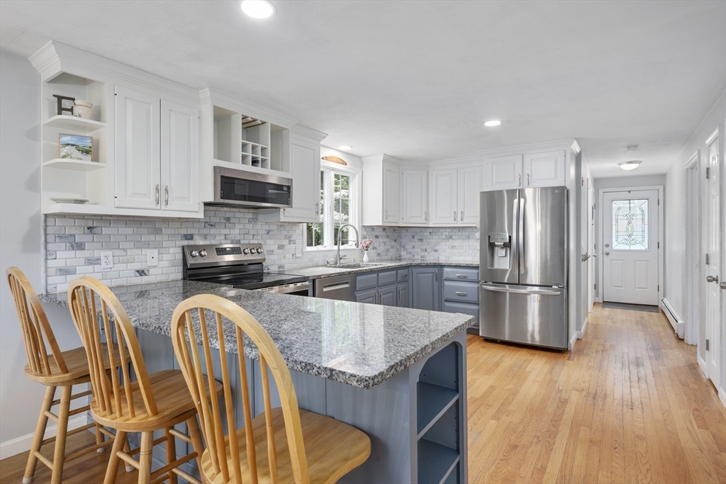 52 Mill Road East Sandwich, MA 02537 - Photo 6 of 36 a kitchen with stainless steel appliances granite countertop a refrigerator a stove top oven a sink dishwasher and a refrigerator with wooden floor