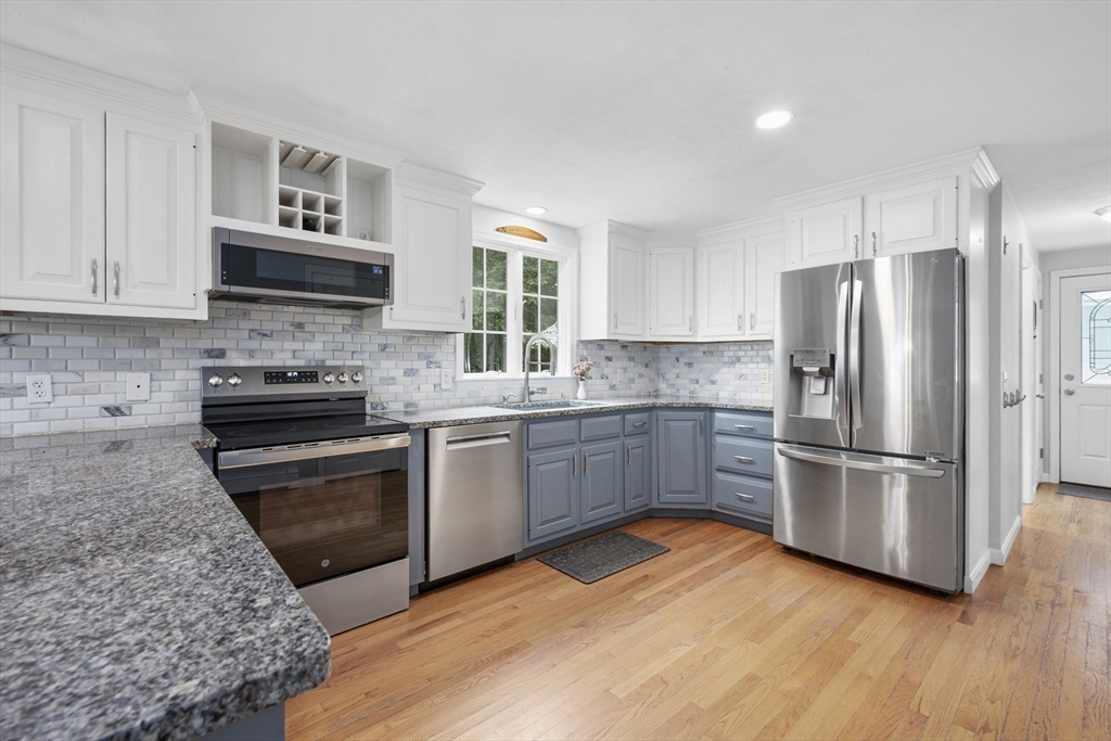 52 Mill Road East Sandwich, MA 02537 - Photo 7 of 36 a kitchen with a refrigerator stove and wooden cabinets