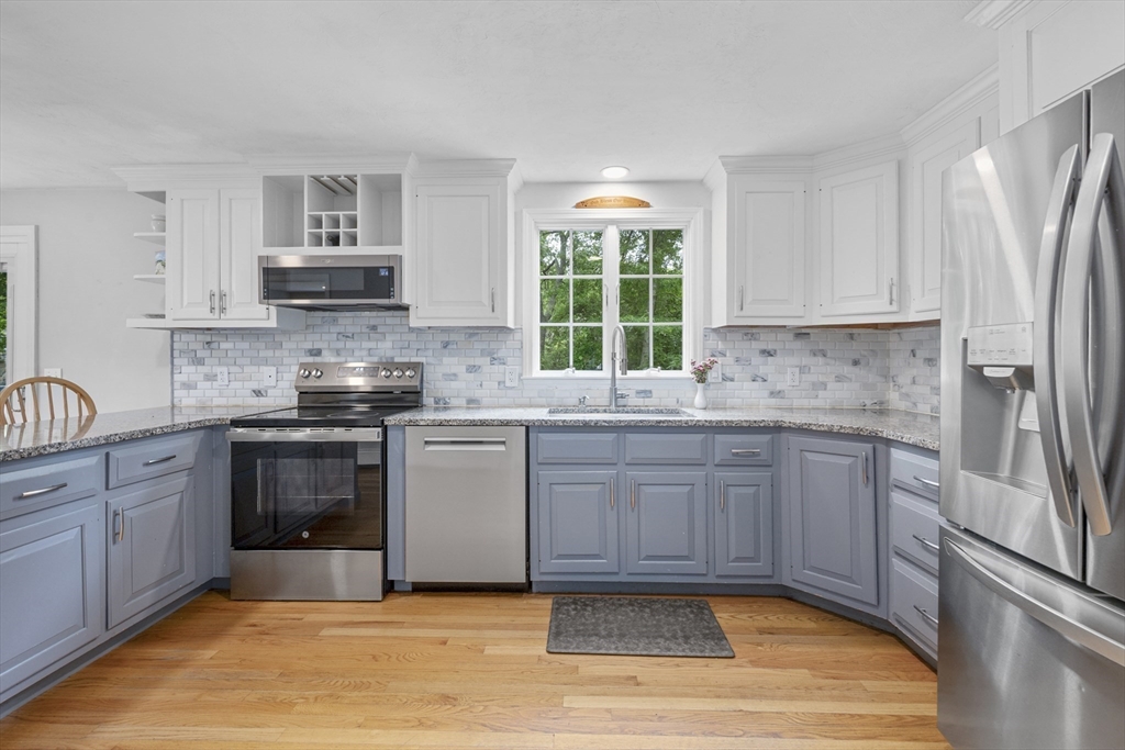 52 Mill Road East Sandwich, MA 02537 - Photo 8 of 36 a kitchen with stainless steel appliances granite countertop a stove a sink and a refrigerator