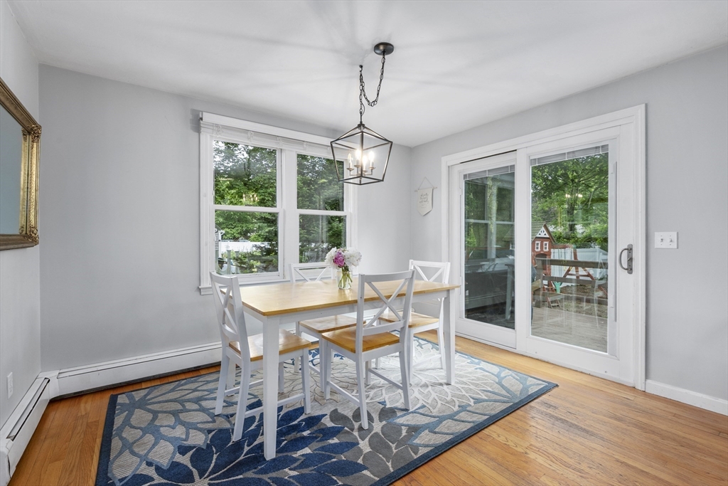 52 Mill Road East Sandwich, MA 02537 - Photo 10 of 36 a dining room with wooden floor a chandelier a wooden table and chairs
